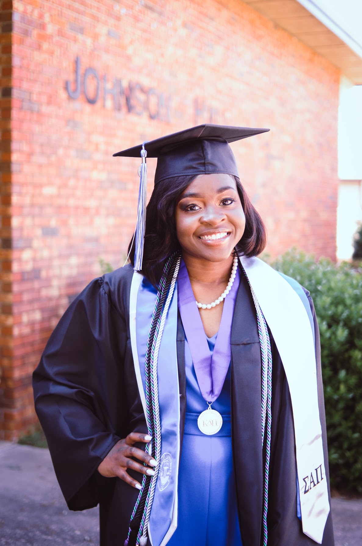 Zanesha Rhodes poses in her graduation regalia outside Johnson Hall, where she spent much of her time as a College of Education student. 