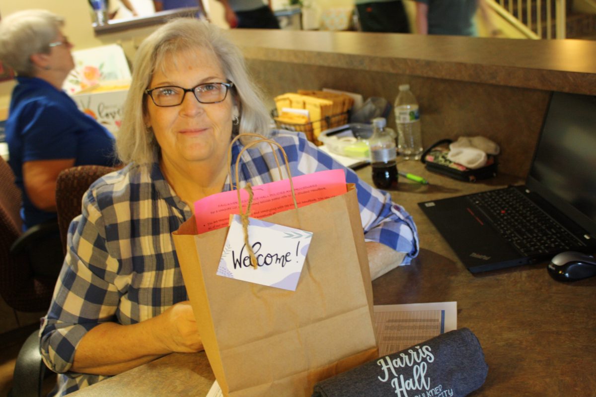 Peggy  Oliver sits at the front desk of the women's dormitory with a gift bag to welcome freshmen girls to their new home away from home.