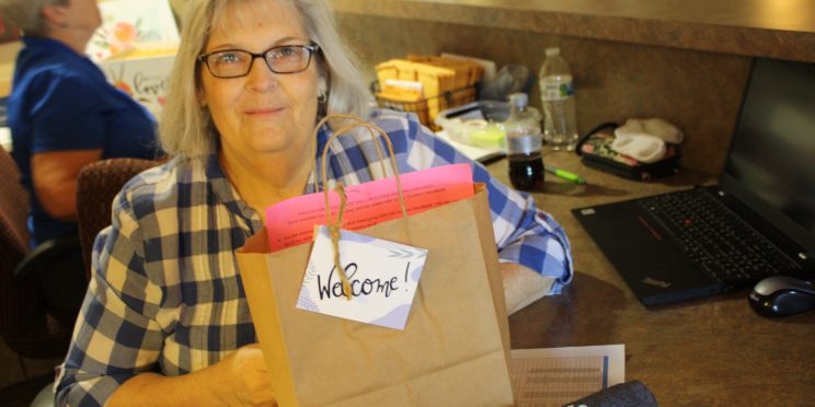 Peggy Oliver sits at the front desk of the women's dormitory with a gift bag to welcome freshmen girls to their new home away from home.