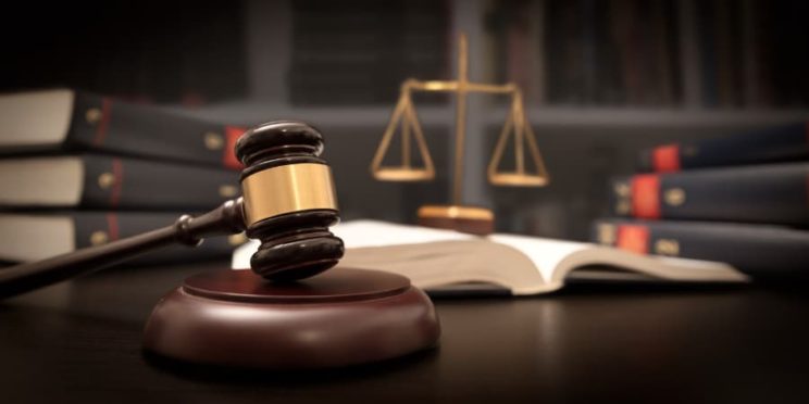 Judge’s gavel with justice scale and law books in background