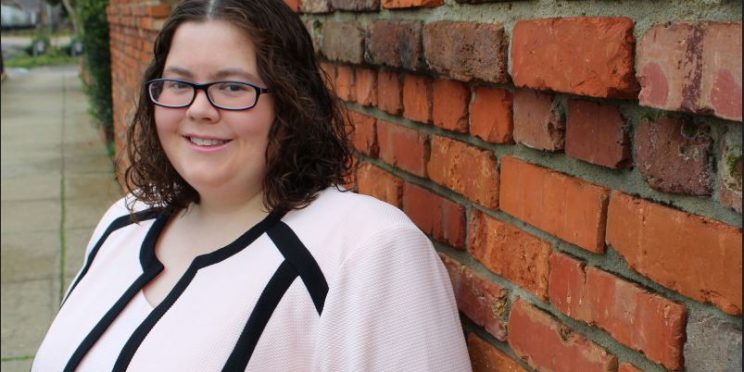 Lauren James stands beside a brick wall. She works as an attorney at Beasley Allen Law Firm and serves through her pro bono work.