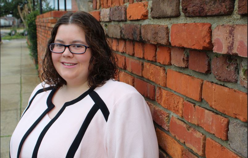 Lauren James stands beside a brick wall. She works as an attorney at Beasley Allen Law Firm and serves through her pro bono work.  