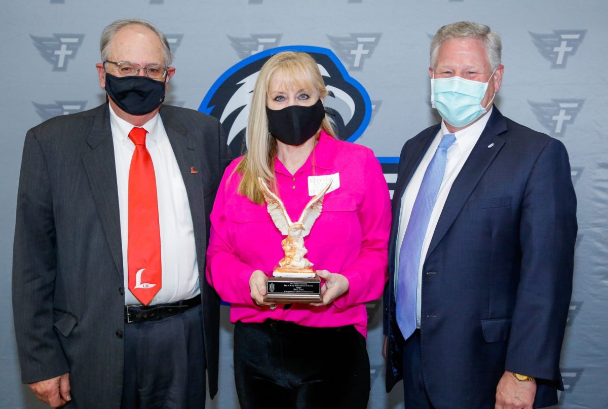 Dr. Jack Zorn's daughter, Rhonda Fernandez, center, stands with Lads2Leaders Executive Director Roy Johnson left, and Faulkner President Mike Williams, right. 