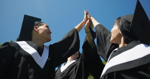 Graduates in caps and gowns celebrate