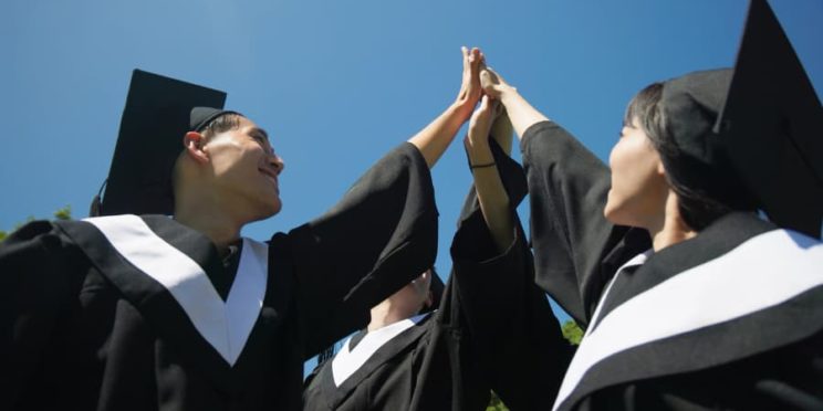 Graduates in caps and gowns celebrate