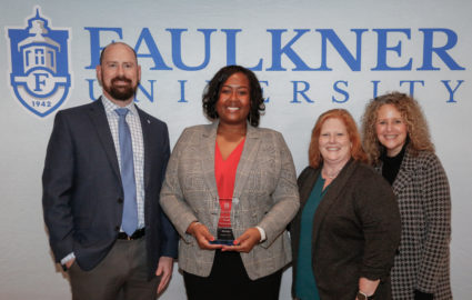 l-r, Justin Bond, Michelle Gaines, Rayla Black, Natasha Kasarjian pose in front of a Faulkner backdrop. Gaines is holding her award from the Marketplace Faith Friday Forums. .