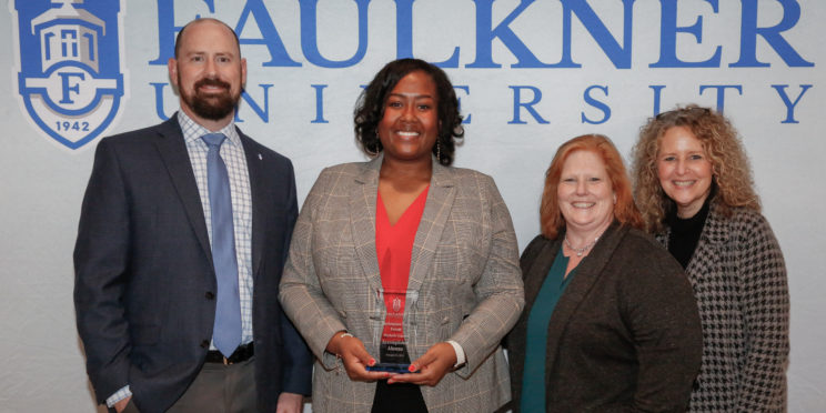 l-r, Justin Bond, Michelle Gaines, Rayla Black, Natasha Kasarjian pose in front of a Faulkner backdrop. Gaines is holding her award from the Marketplace Faith Friday Forums. .