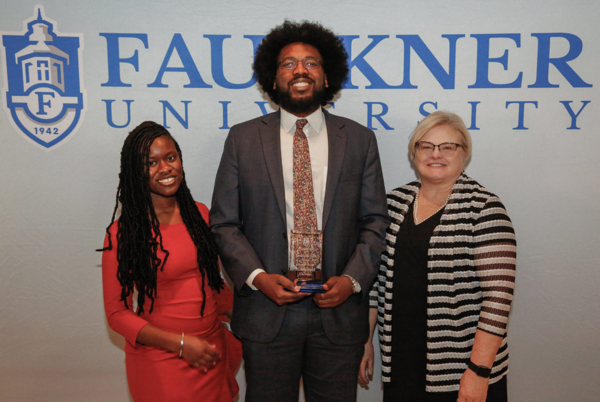 Center, Ahmad Smith stands with his Mia Jones, left, and Cathy Davis after being awarded Accomplished Alumnus for his role as Deputy DA in Montgomery County.