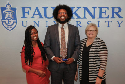 Center, Ahmad Smith stands with his Mia Jones, left, and Cathy Davis after being awarded Accomplished Alumnus for his role as Deputy DA in Montgomery County.