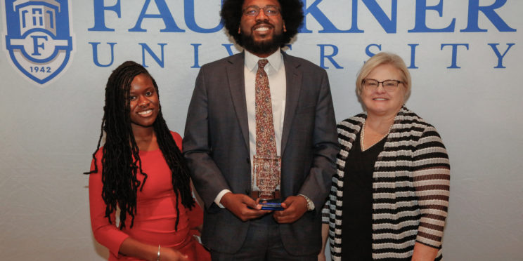Center, Ahmad Smith stands with his Mia Jones, left, and Cathy Davis after being awarded Accomplished Alumnus for his role as Deputy DA in Montgomery County.