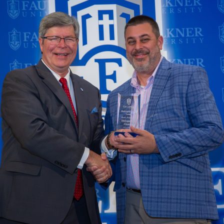 Ryan Frederick receives the Distinguished Alumnus Award from Faulkner President Mitch Henry.
