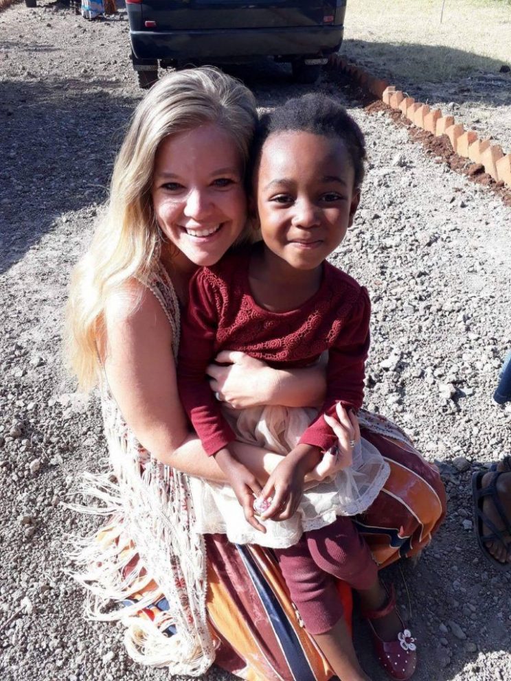 Anna Maynard holds a child from the village they serve in Tanzania, Africa.