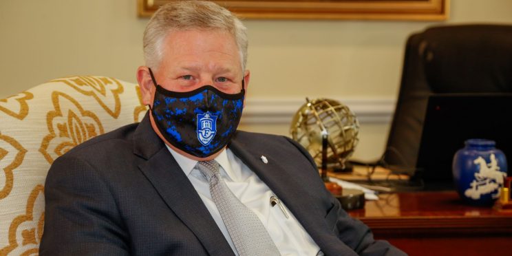 Faulkner University President Mike Williams wears a face mask with the Faulkner logo.