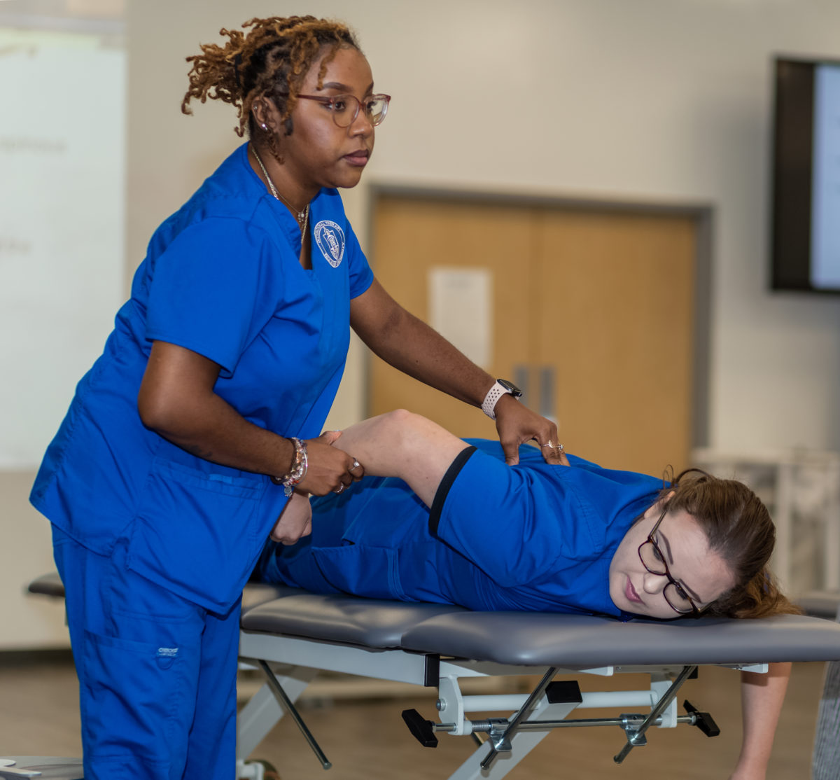 OTD students palpate muscles of the scapula and feel movements of the scapula during shoulder motions for their lab work.