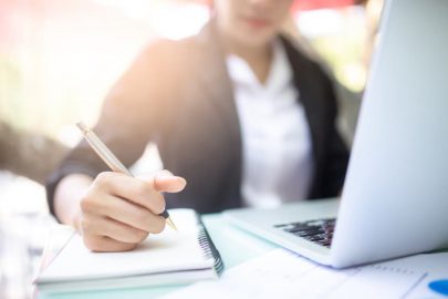 Young woman working with a laptop and notebook