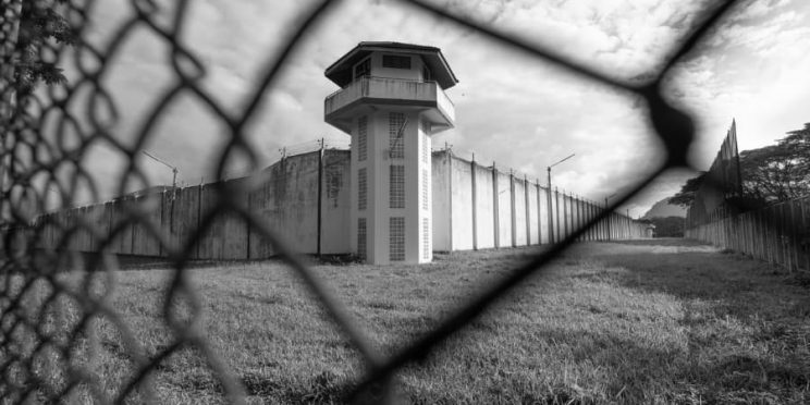 Prison watchtower behind fence