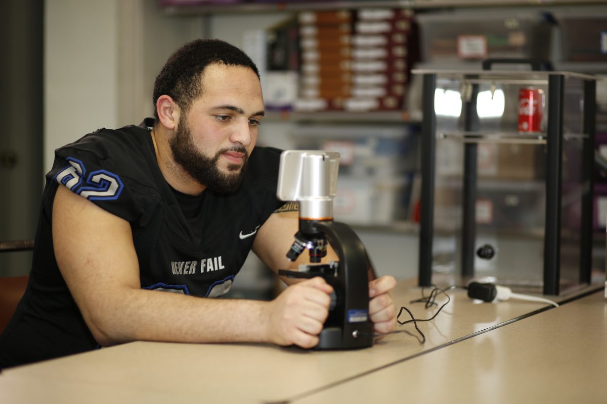 Malik Washington peers into a digital microscope in the Criminal Justice lab.