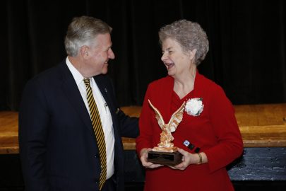 Olivia Mae Burt accepts the Alumna of the Year Award from Faulkner President Mike Williams.