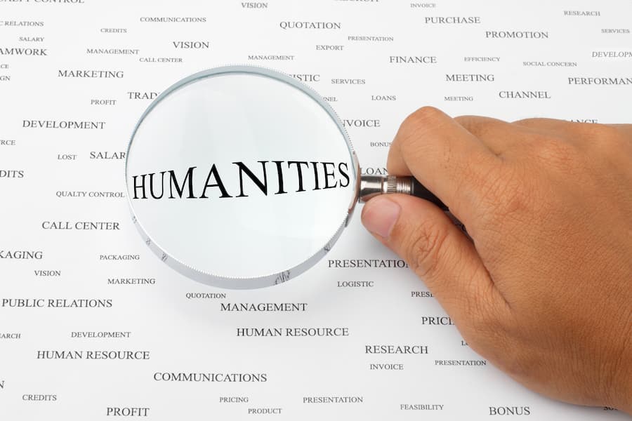 Page with words on it with humanities in center under magnifying glass