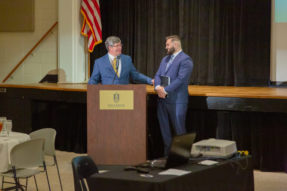 President Henry calls Sam Jackson to the podium during the President's Circle luncheon. 