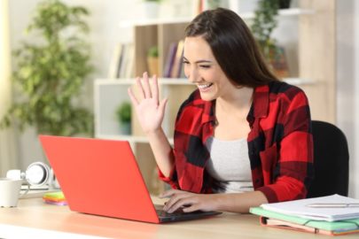 Smiling college student greets classmates on a video call