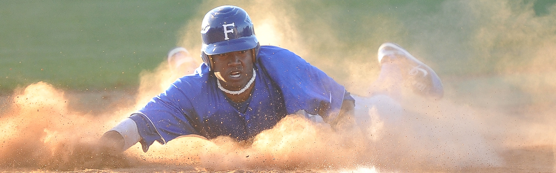 Baseball player sliding into base.