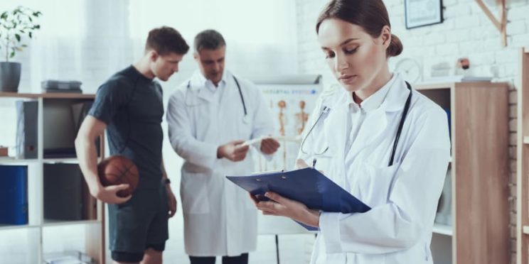 Sports psychologists talking to a basketball player in a clinic