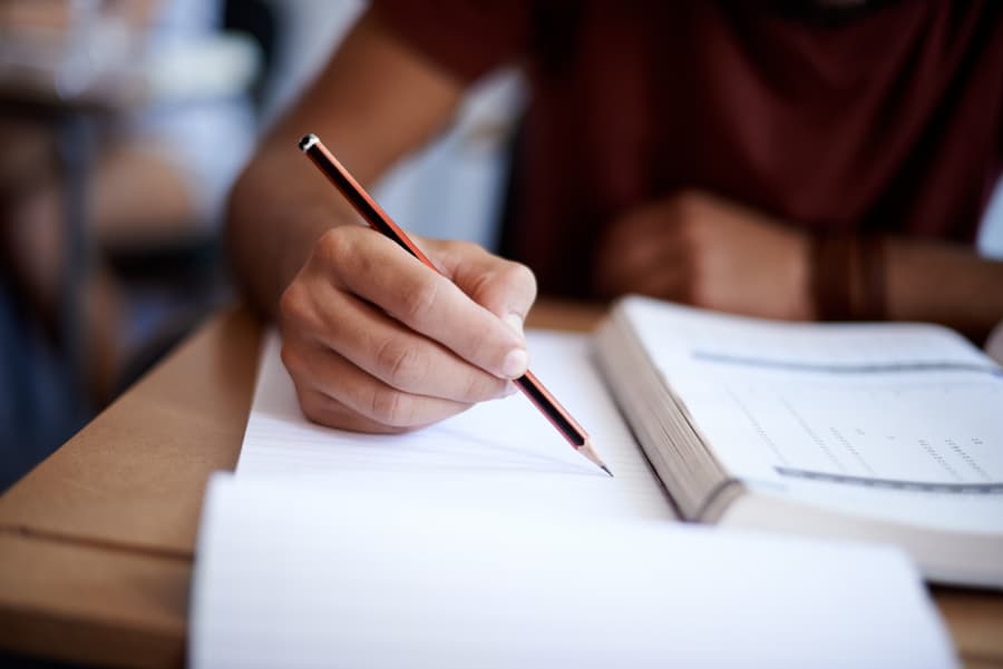 Student-holding-pencil-taking-notes Student holding pencil taking notes