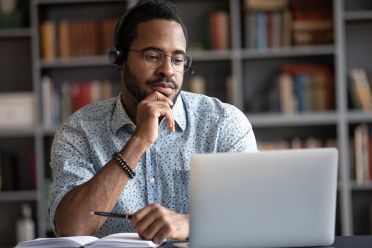 Student wearing headphones studying on laptop