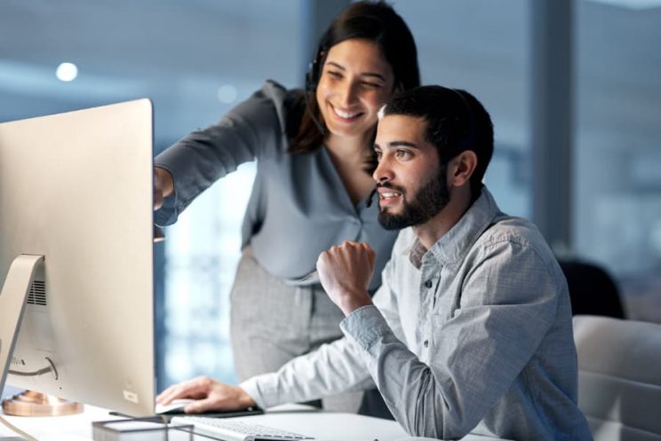 Teacher and Student Look at Computer Screen