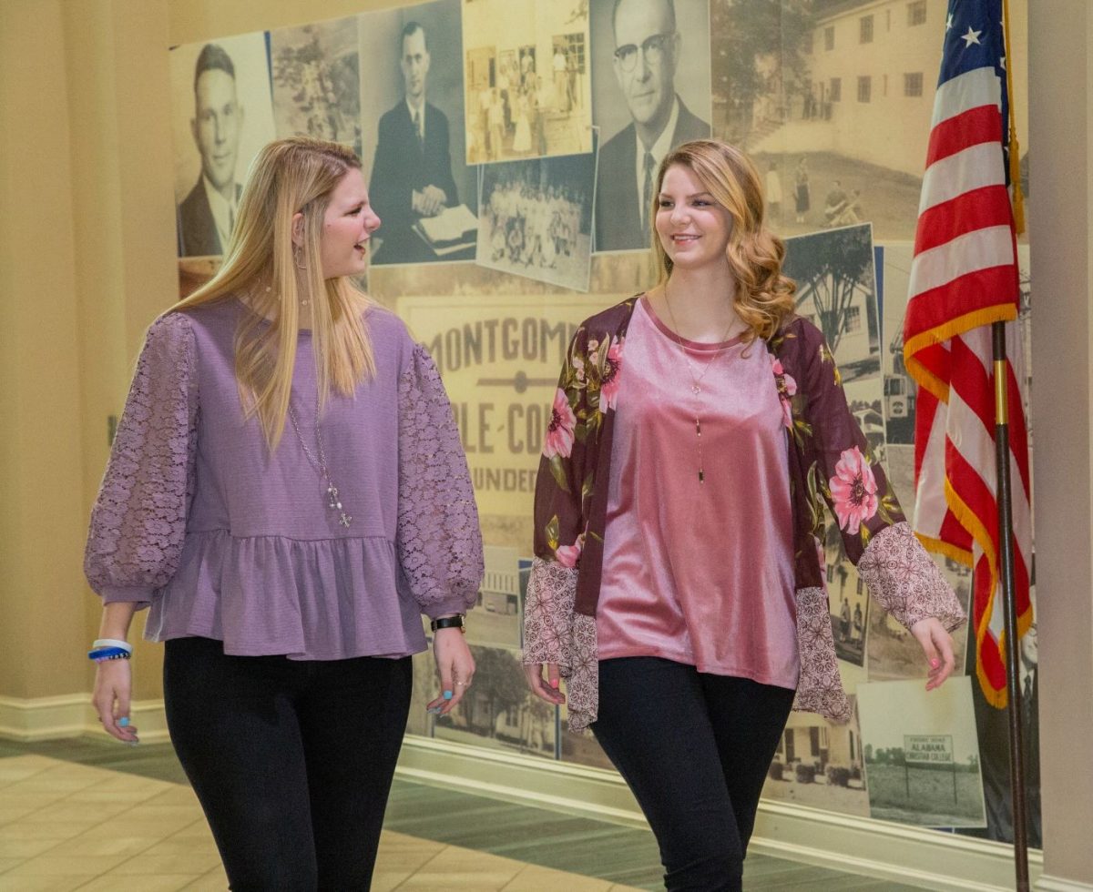 l-r: Victoria McDaniel and her sister Olivia McDaniel chat as the walk a corridor of campus. 