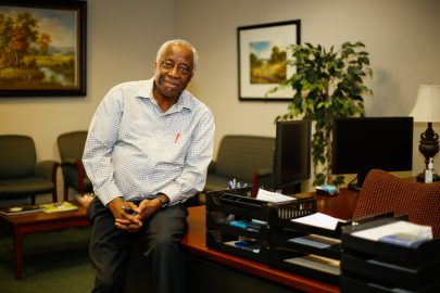 Michael Walcott sits on his desk.