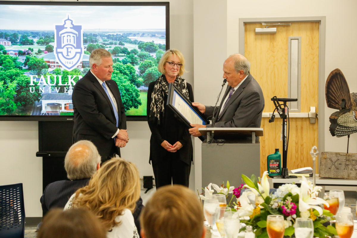 Dale Kirkland, right, reads the resolution to Mike and Lisa Williams, to name the autism center the Mike and Lisa Williams Center of Autism. 