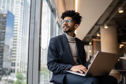 Businessperson with computer, looking out window