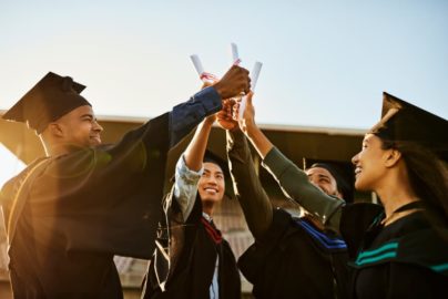 Cheerful graduates holding diplomas