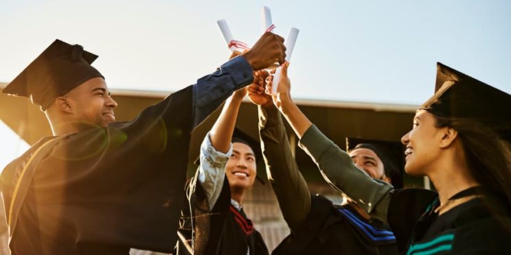 Cheerful graduates holding diplomas