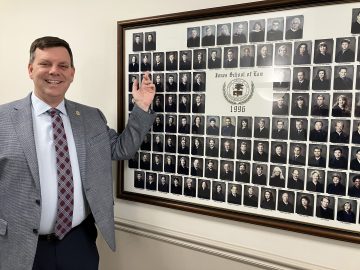 Daryl Bailey points to a picture of himself with the Faulkner Law graduating class of 1996.