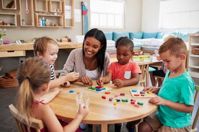 Education Student Playing with Children at Table