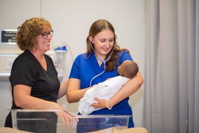 Faulkner university nursing student holding a baby in training