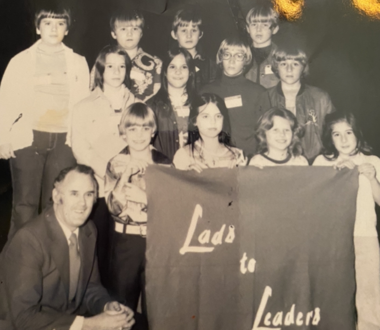 Dr. Jack Zorn, left, sits with a group of young students at a Lads2Leaders Convention. 