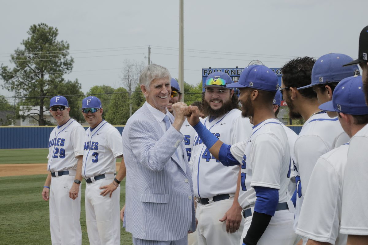 Lamar Harrison shares a fist bump with a Faulkner Eagles Baseball player. 