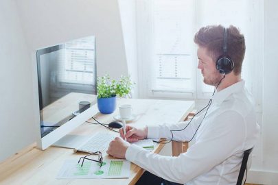 Man with Headphones Taking Online Class on Apple Computer