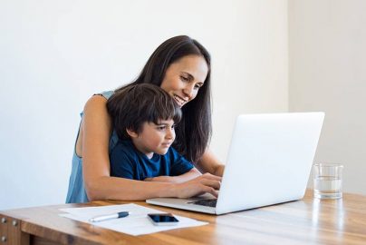 Mother Using Laptop with Son on Lap