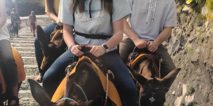 Students ride donkeys in Santorini, Greece.