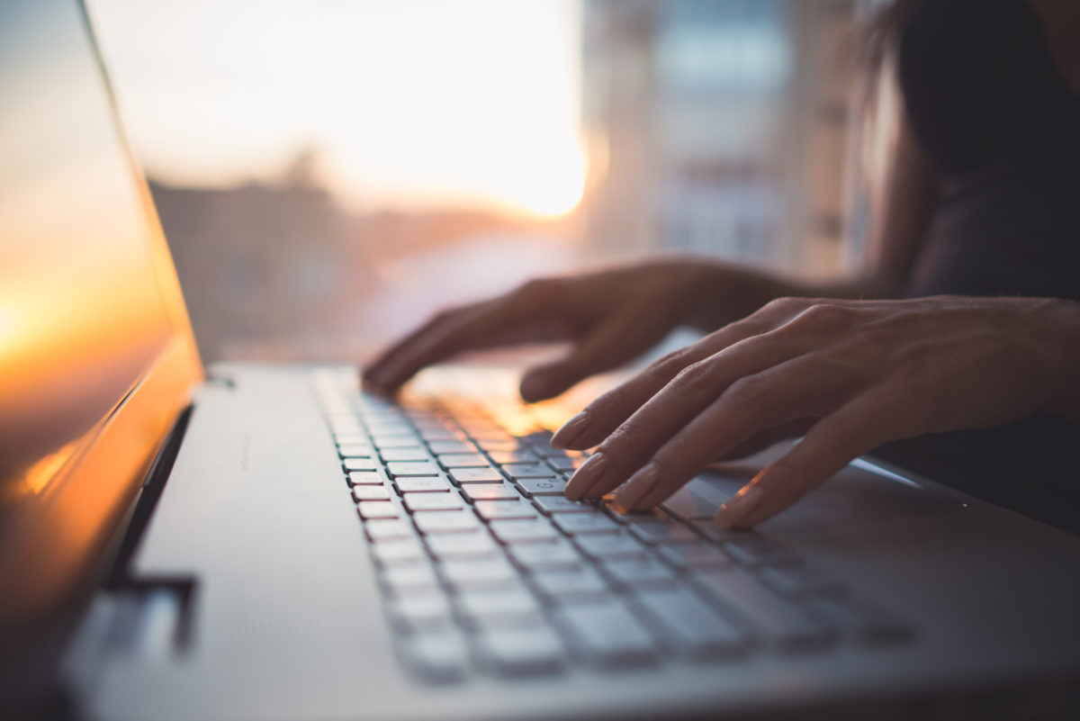 Hands typing on a computer.