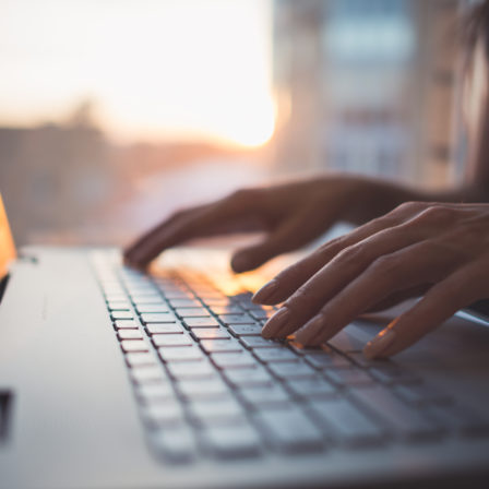 Hands typing on a computer.