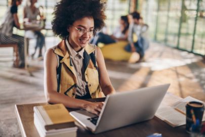 Student sitting in coffee shop working on laptop