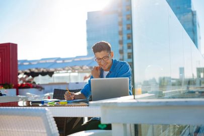 Student Studying on Laptop on Roof Outside