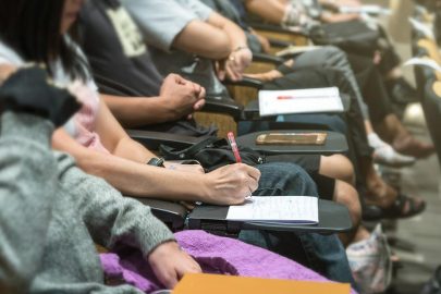 Students Sitting in Row Taking Notes in Class