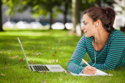 Student Studying in the Park with Earbuds